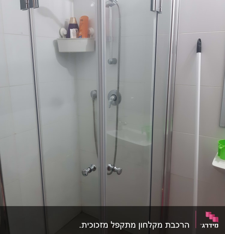 מקלחון זכוכית עם בקבוקי שמפו ומקלחת
